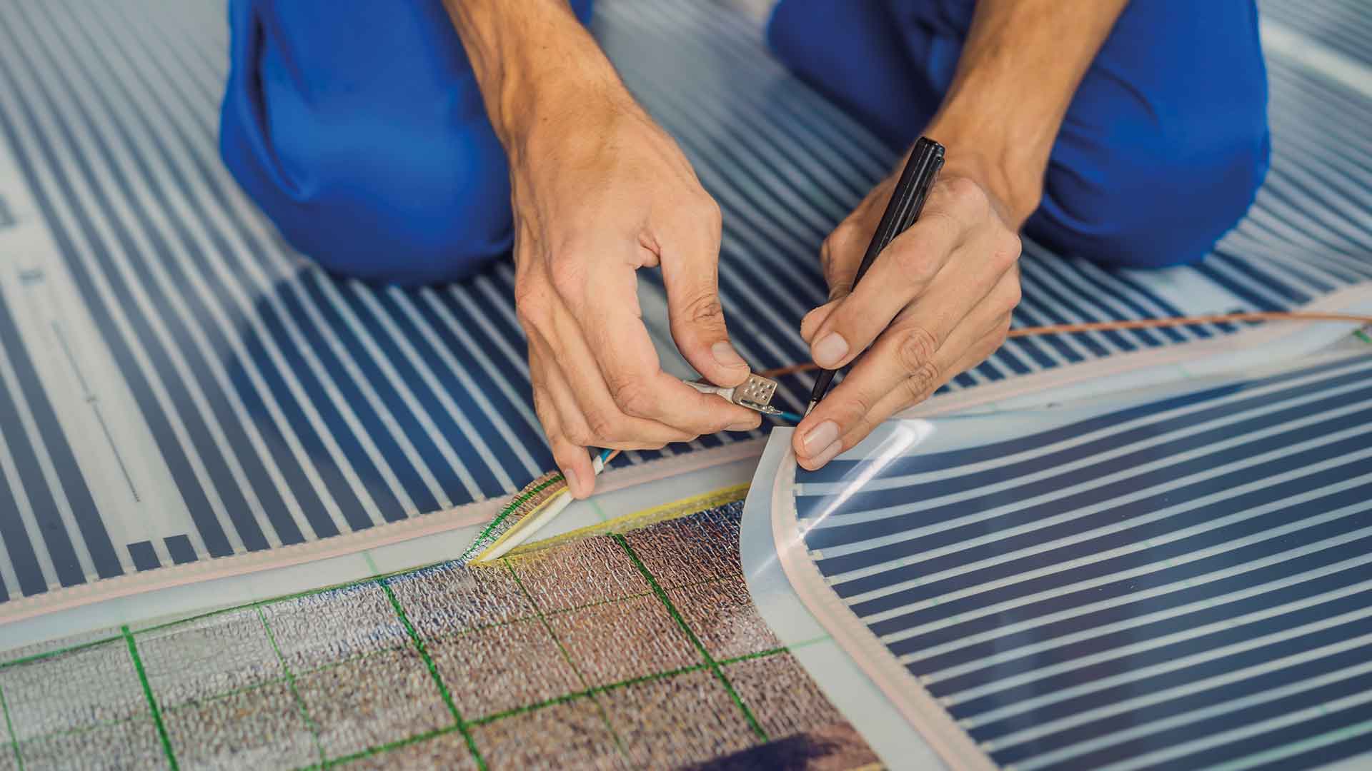 E-Line, ein Handwerker installiert ein elektrisches Heizsystem