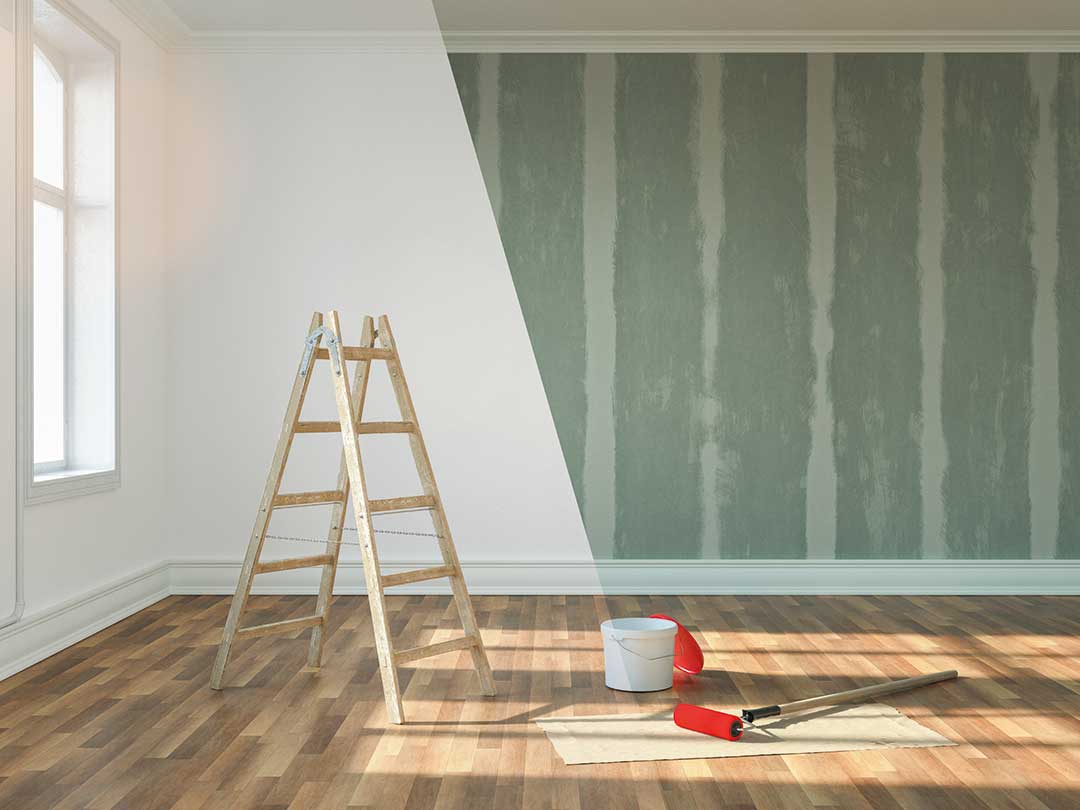 Leiter, Eimer und Farbrolle in Raum, der renoviert wird